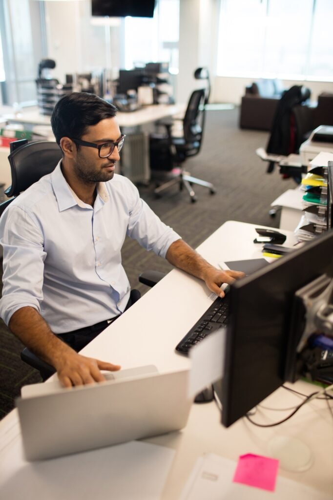 Businessman using laptop and desktop pc together