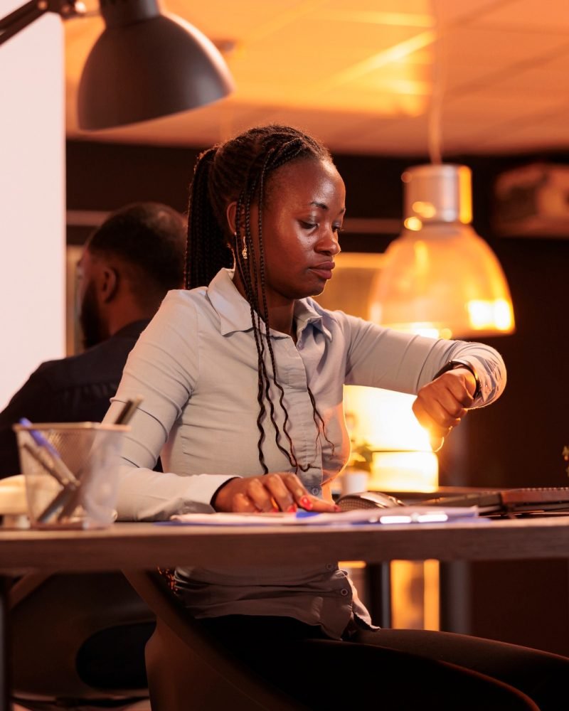 Project manager looking at time on watch to check busy schedule
